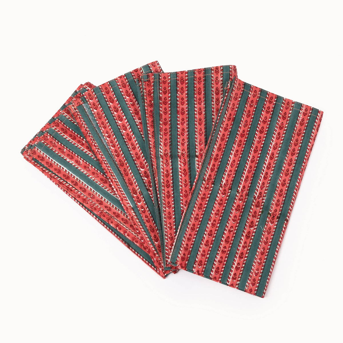 A set of four folded patterned napkins fanned out on a plain white background. The napkins feature vertical stripes of red, green, and white with a small geometric pattern.