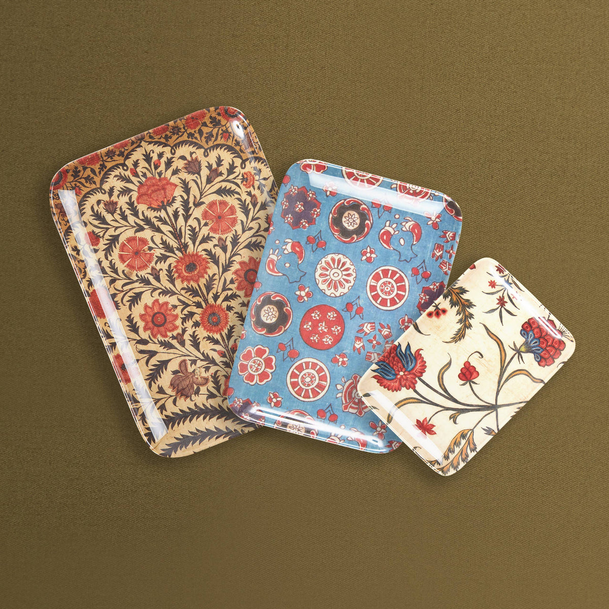 Three floral-patterned trays on a brown background