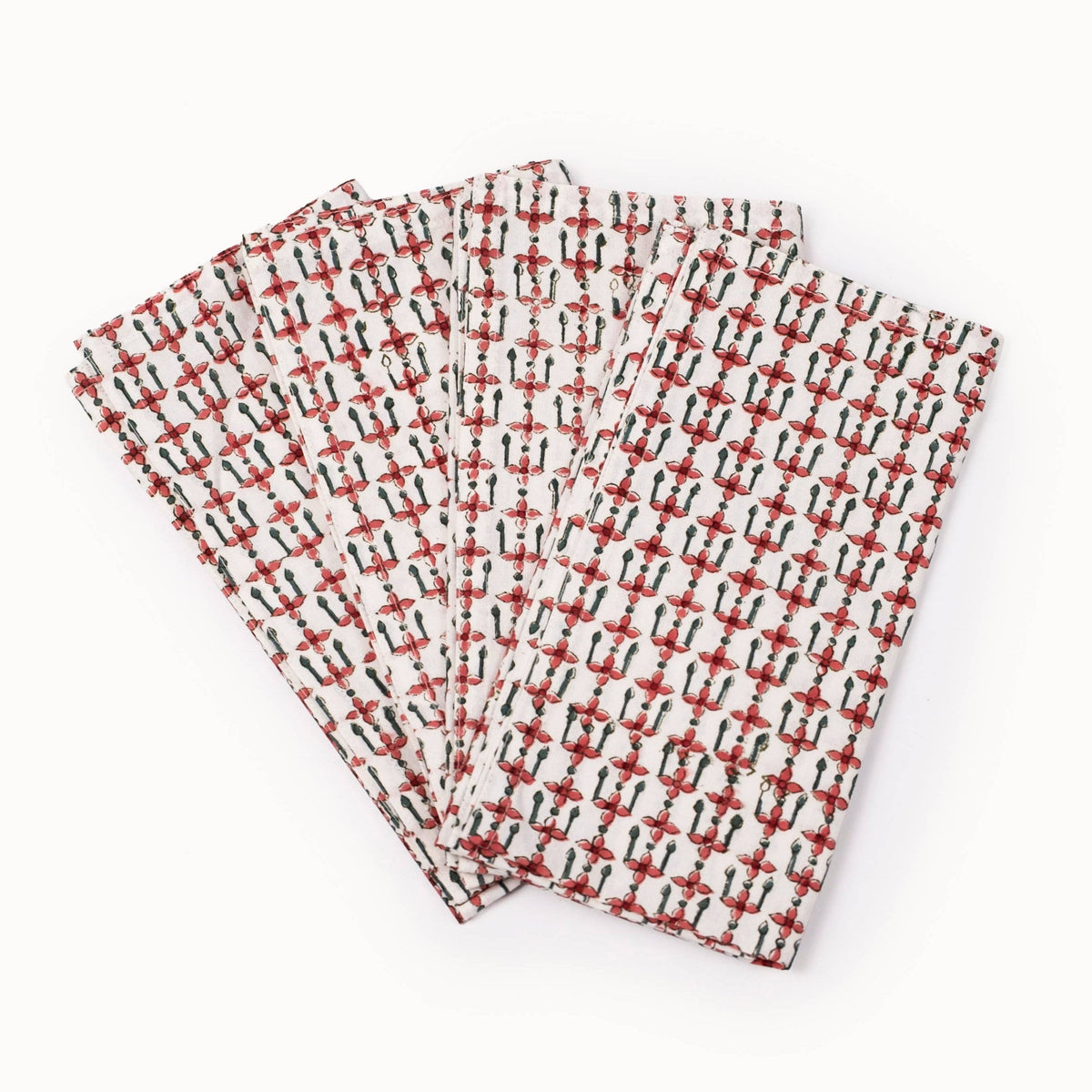 A folded set of four patterned napkins in red, black and off-white, laid flat against a white background.