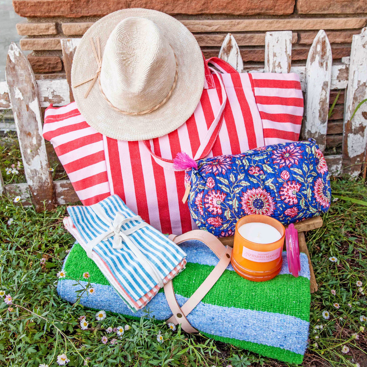 Colorful beach bag with accessories on a grassy area