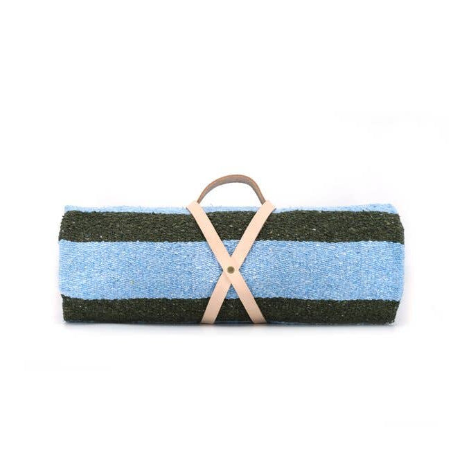 Striped fabric blanket with a leather handle on a white background