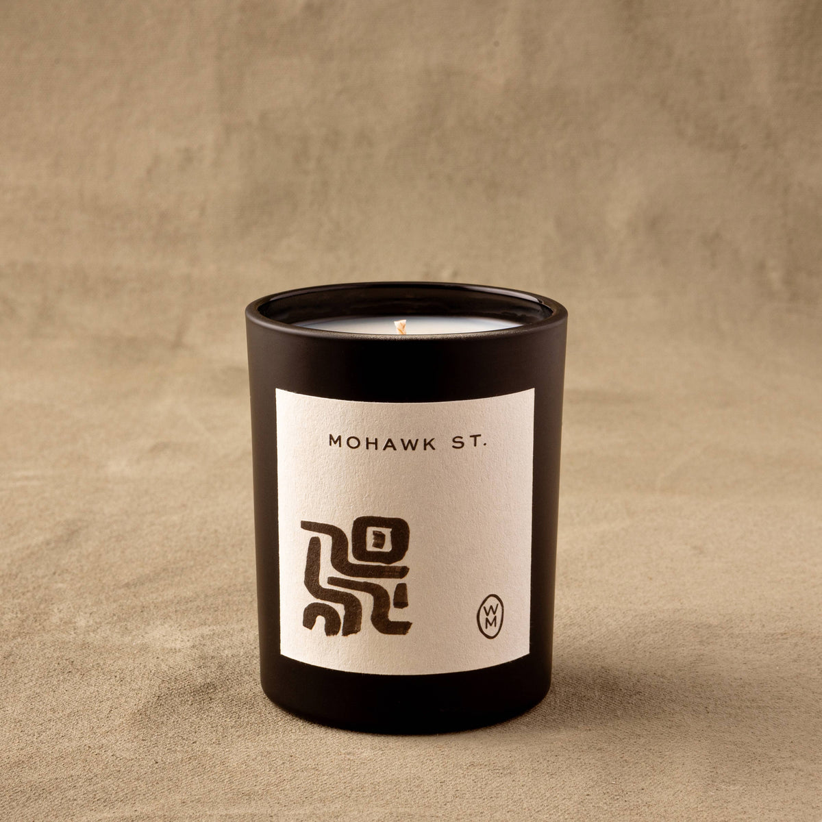 Candle with 'Mohawk St.' label on a beige background